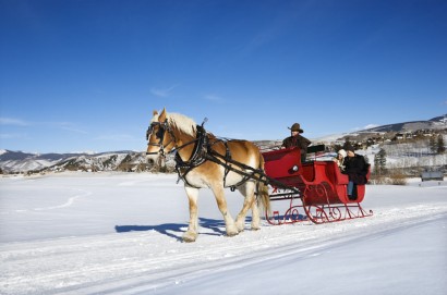 Horse-drawn sleigh ride through romantic mountain scenery