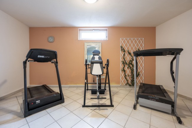 Fitnessraum mit Laufband und Stepper