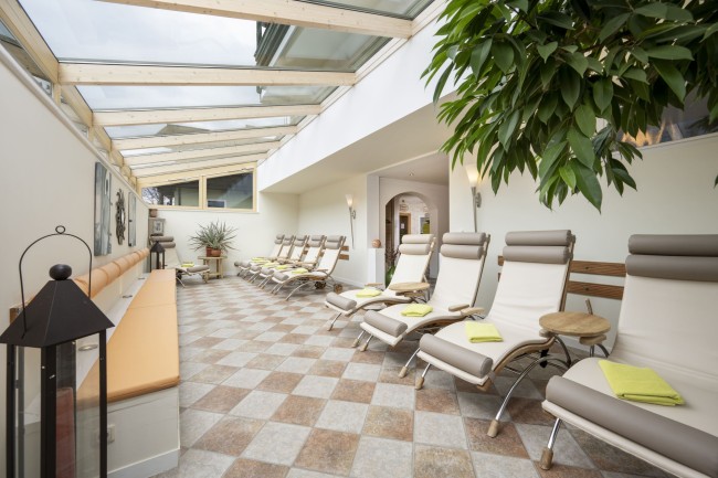 Gem&uuml;tliche Liegen im Ruhebereich mit Sonnendach im Wintergarten